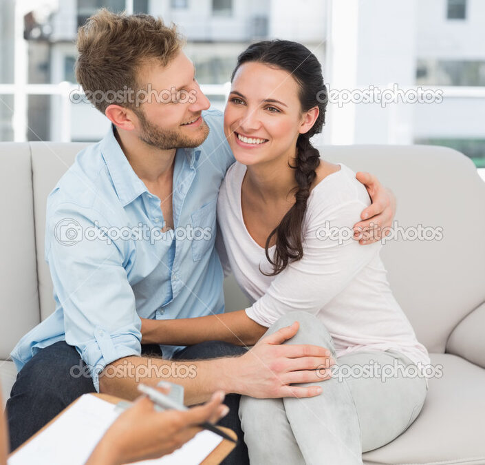 Happy couple reconciling at therapy session in therapists office